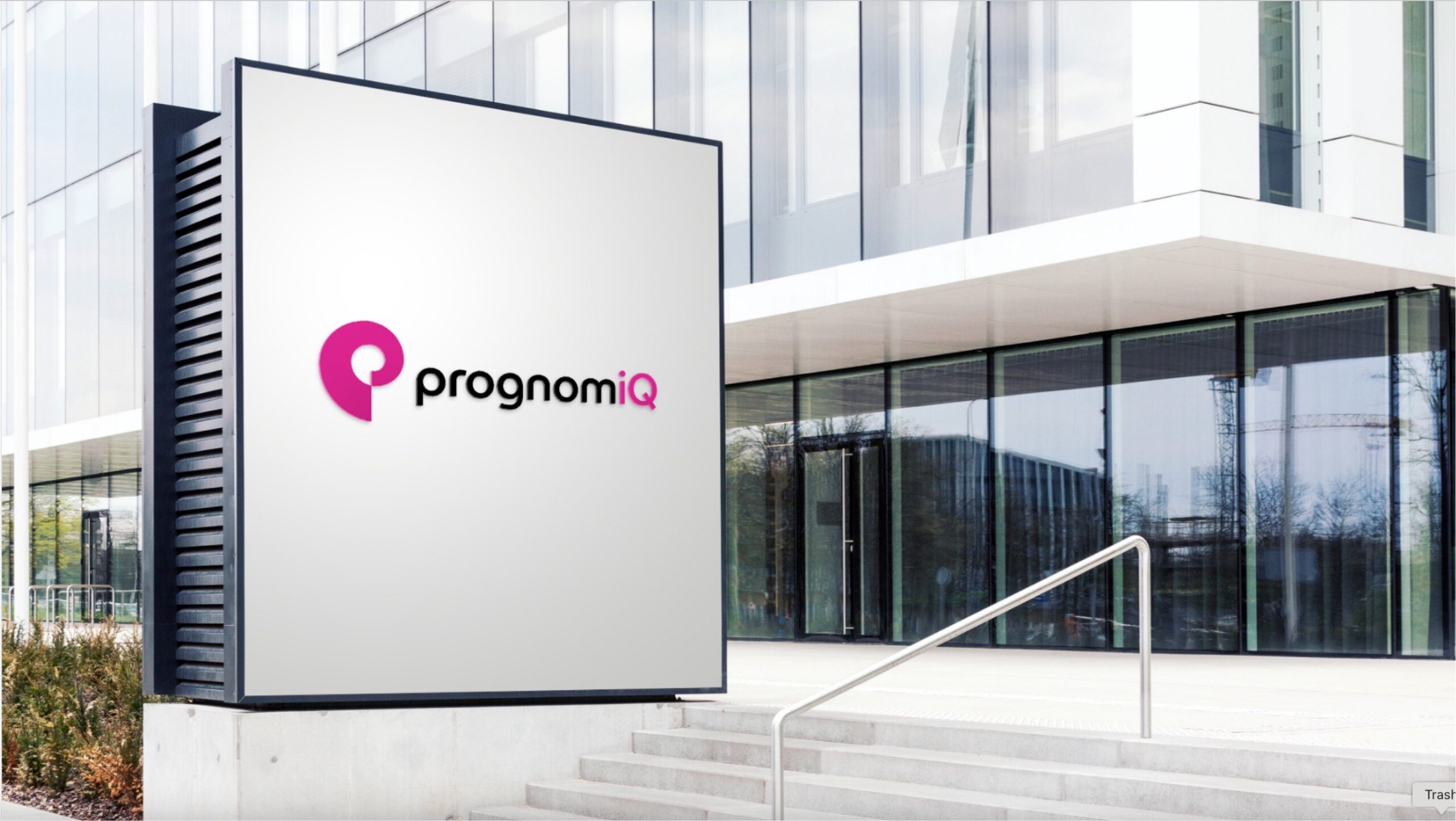 Outside view of building with PrognomiQ's logo on a sign in front next to concrete steps.