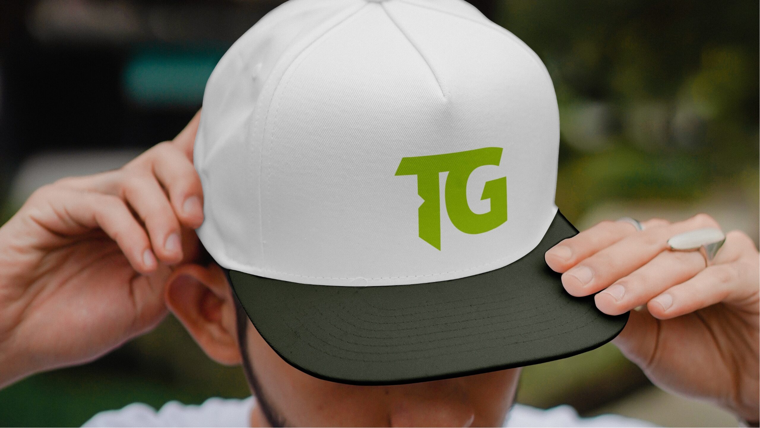 Man wearing a white fitted trucker hat with Transformation Golf's green logo.