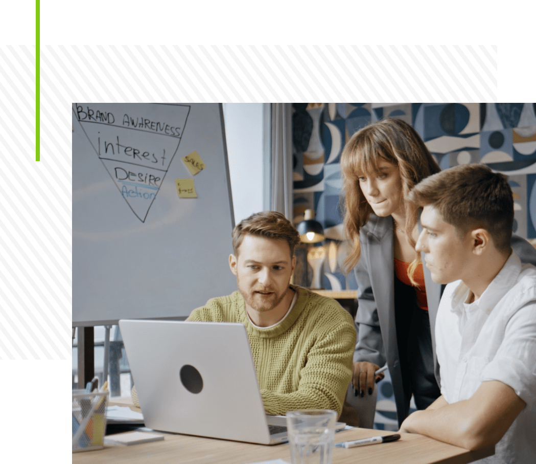 Office workers looking at a laptop, representing practical and scalable applied AI solutions in digital marketing.